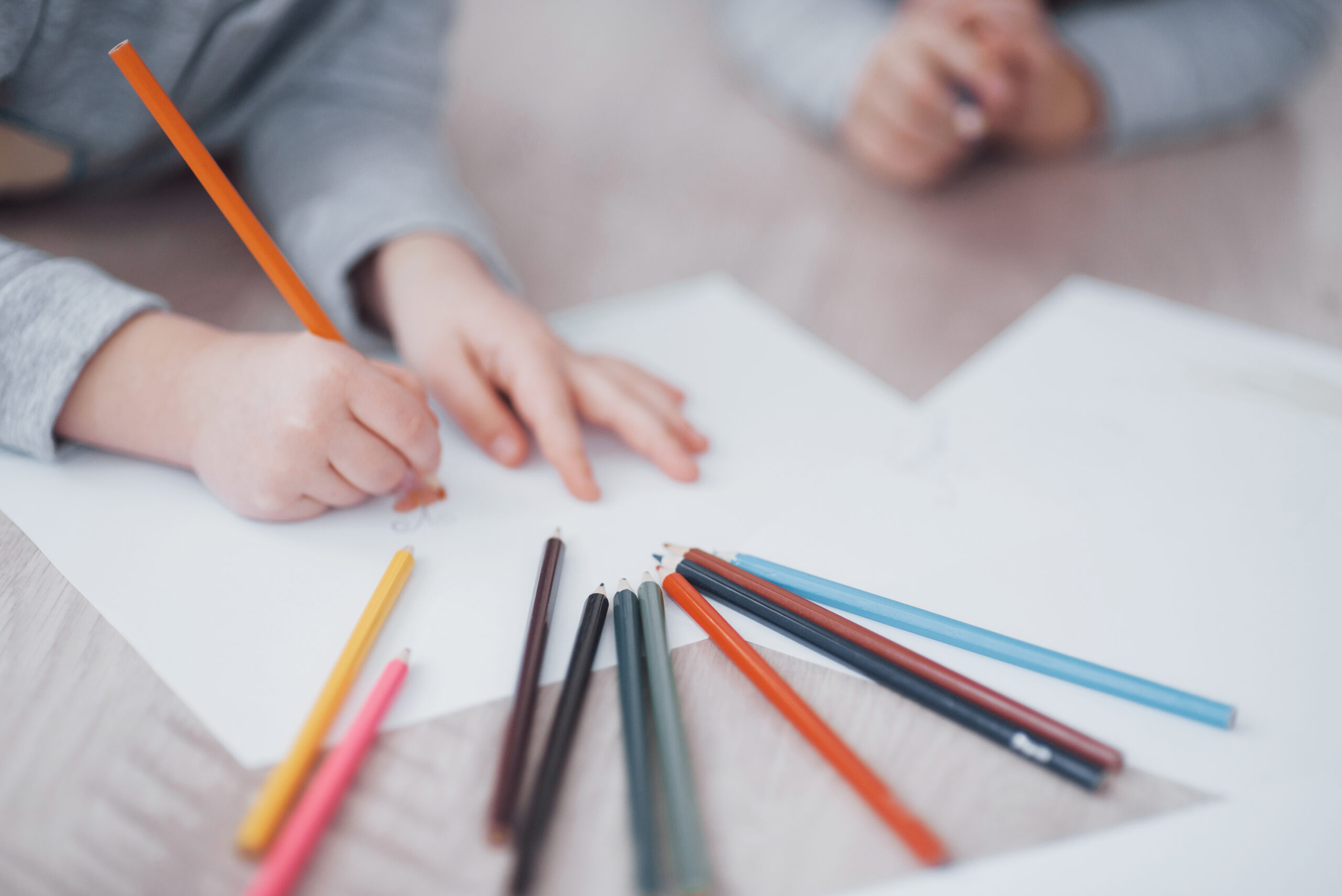 child colouring with coloured pencils for a therapy technique